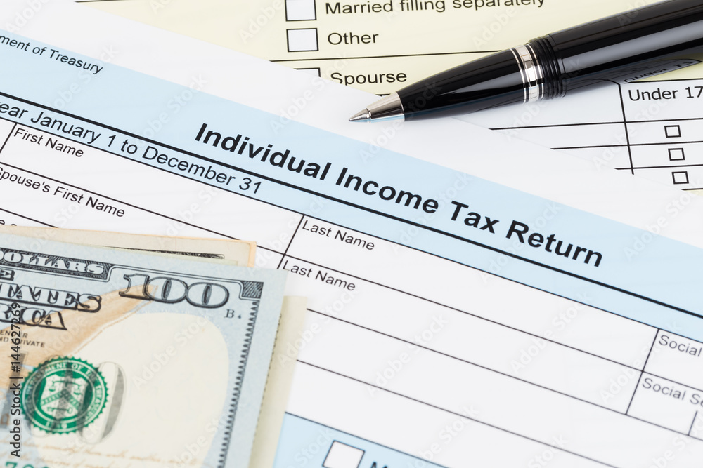 Tax form with pen, and dollar banknote; document are mock-up Tax form with pen, and dollar banknote; document are mock-up