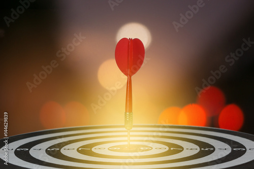 target dart with arrow over blurred bokeh background ,metaphor to target marketing or target arrow concept.