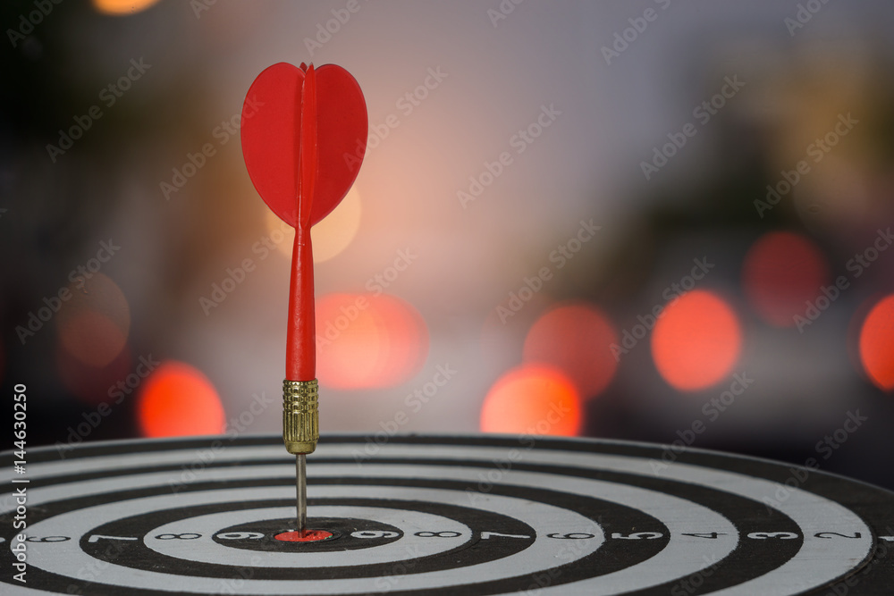 target dart with arrow over blurred bokeh background ,metaphor to target marketing or target arrow concept. target dart with arrow over blurred bokeh background ,metaphor to target marketing or target arrow concept.