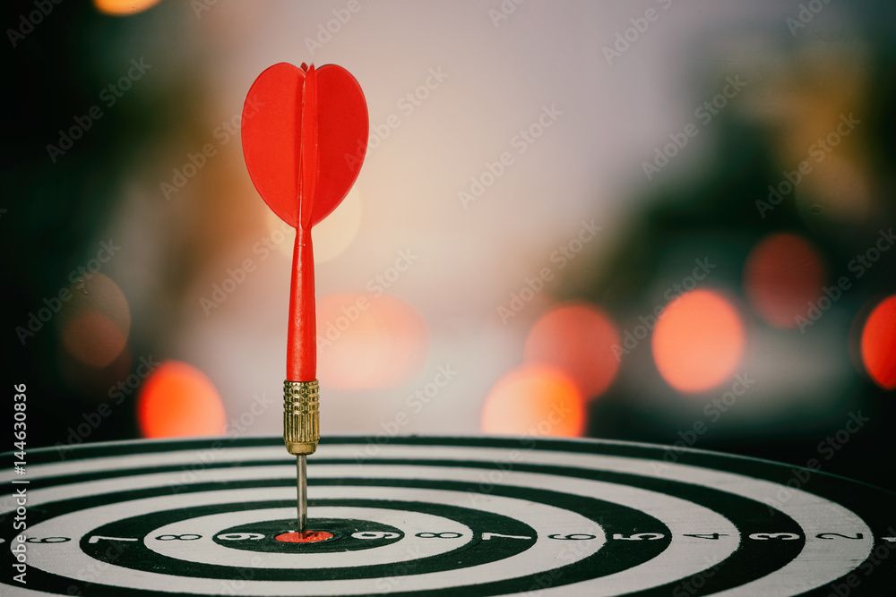 target dart with arrow over blurred bokeh background ,metaphor to target marketing or target arrow concept. target dart with arrow over blurred bokeh background ,metaphor to target marketing or target arrow concept.