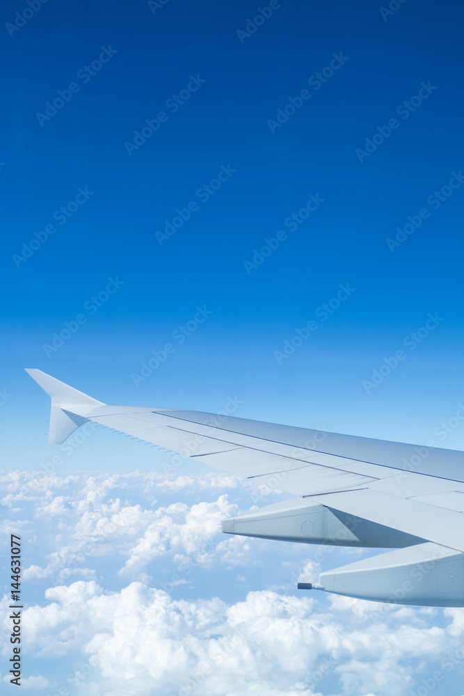 Airplane wing above cloud seen through window Airplane wing above cloud seen through window