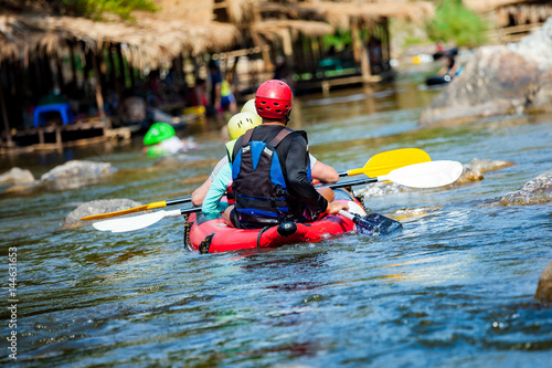 Young men and women are rafting on the river, extreme and fun sport at tourist attraction
