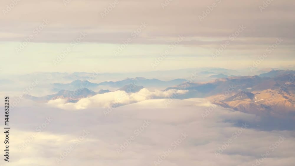 Aerial view of clouds and snow covered Alps mountains seen from a Plane Aerial view of clouds and snow covered Alps mountains seen from a Plane