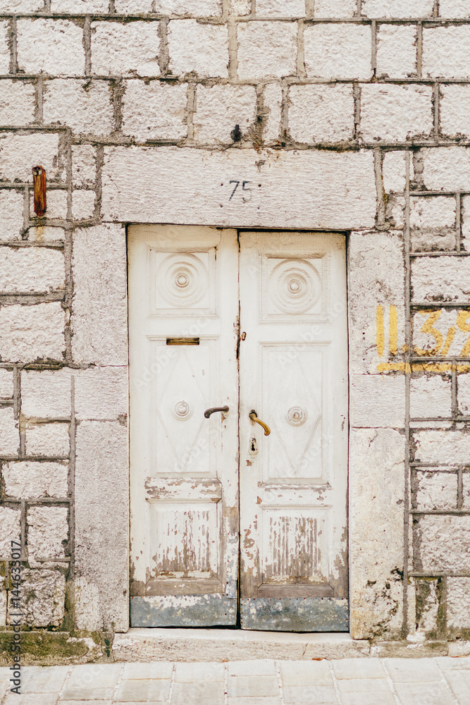 Old white doors. Wood texture. Old shabby, irradiated paint