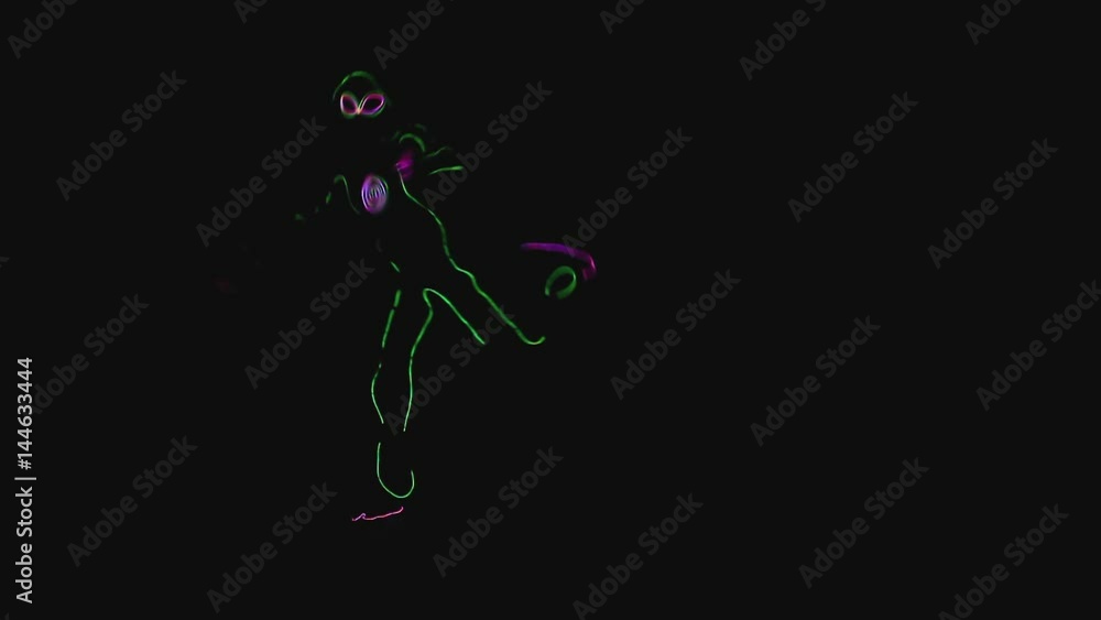 The guy dances in a luminous suit. Silhouette of an alien. The guy dances in a luminous suit. Silhouette of an alien.