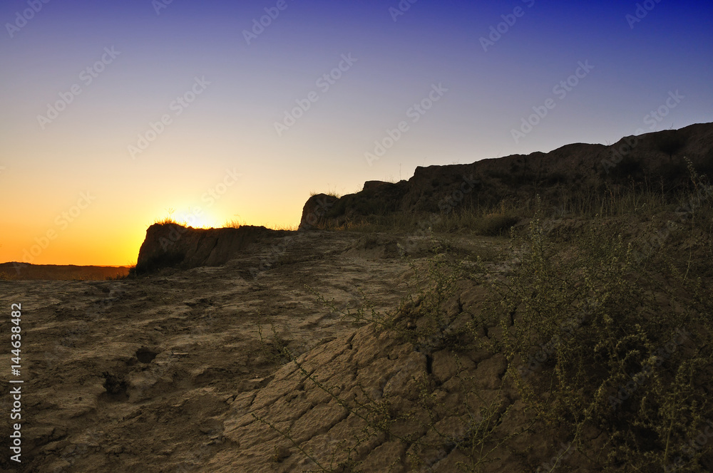 Evening landscape with dry cracked earth