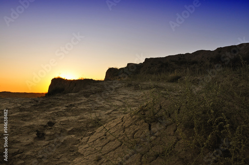 Evening landscape with dry cracked earth