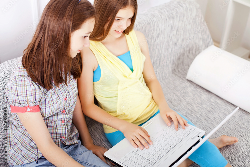 Two preteen girls using laptop. Two preteen girls using laptop.