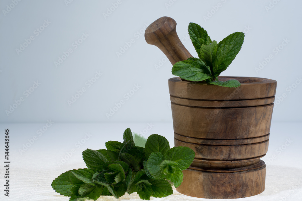 Fresh green mint in olive wood mortar - ready to use