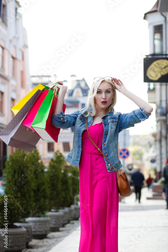 Smiling girl with shopping bags. Walks the streets of the city