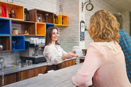 female barista and the customer in a cafe