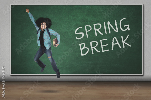 College student leaping with spring break text © Creativa Images