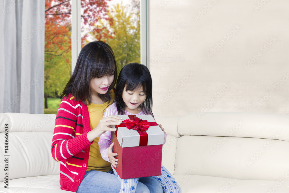 Obraz premium Cute daughter and mother open give box