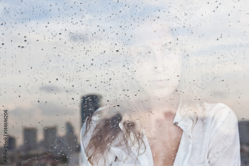 Melancholy reflection of the girl in the window