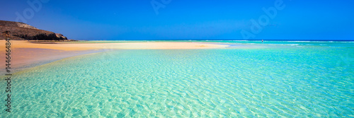 Island with sandy beach, green lagoon and clear water, Fuerteventura, Canary island, Spain. photo