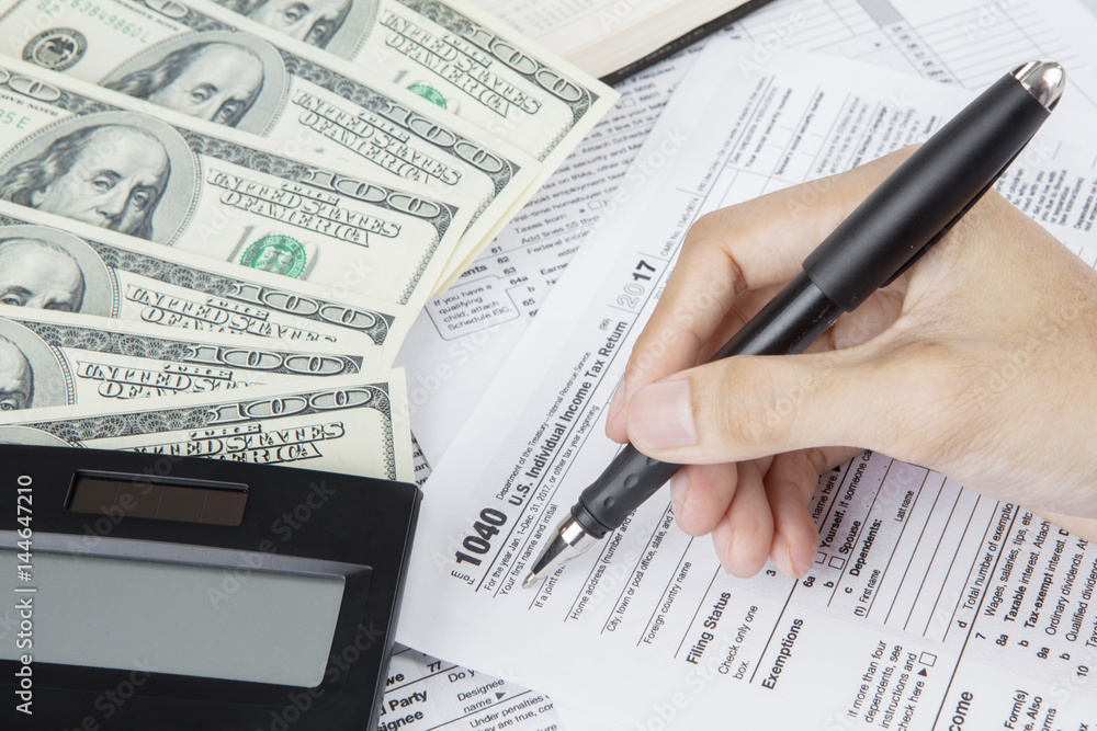 Obraz premium Hands of worker writes on the tax form