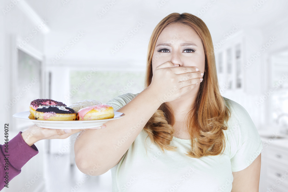 Obese woman closed mouth for donuts