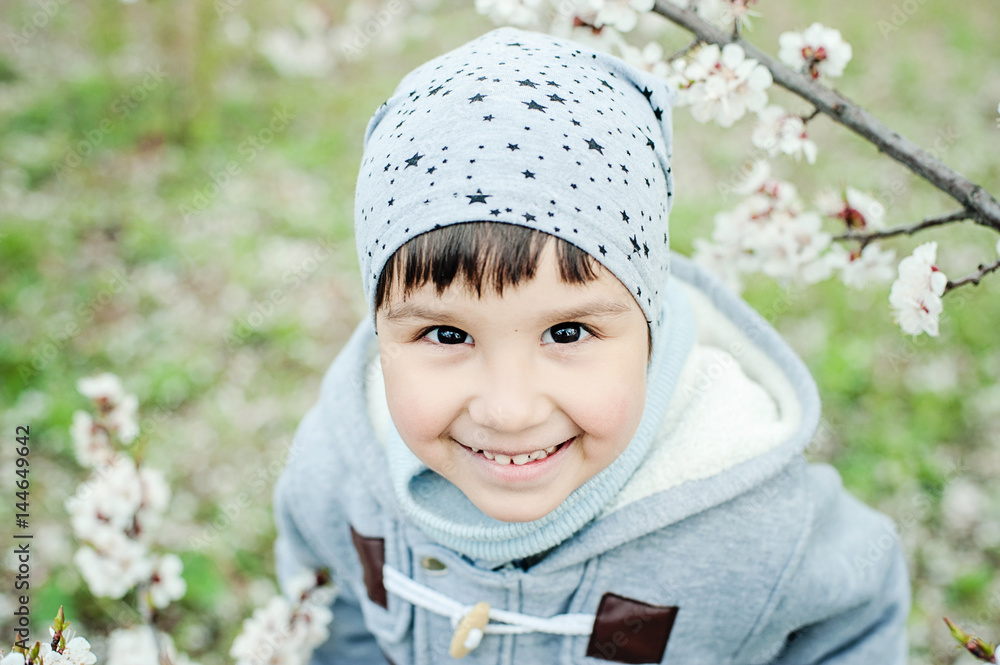 Half-length portrait of a little boy in grey hat looking up and smiling Half-length portrait of a little boy in grey hat looking up and smiling