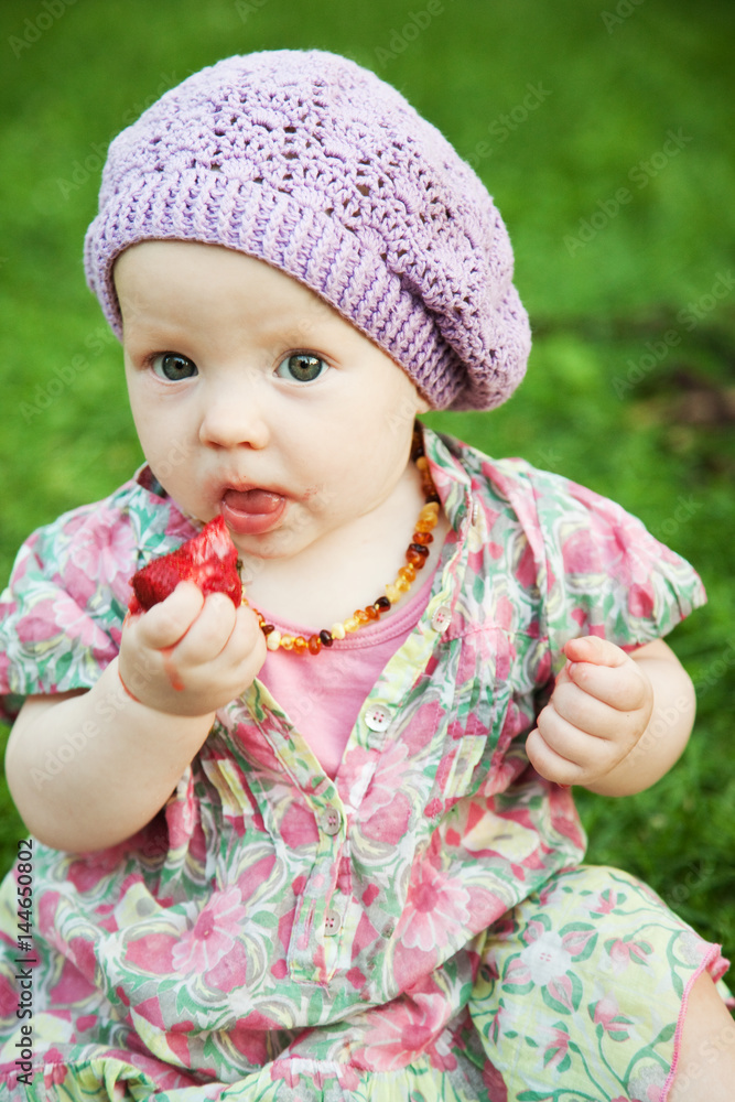 Little girl eating strawberries on the grass Little girl eating strawberries on the grass
