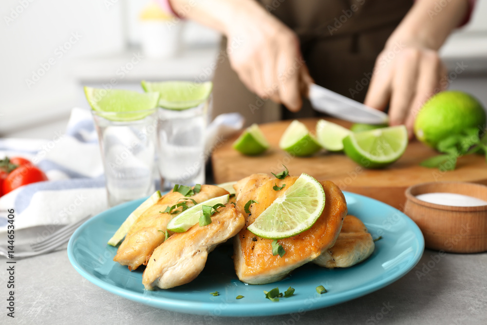 Plate of delicious tequila lime chicken and woman on background Plate of delicious tequila lime chicken and woman on background