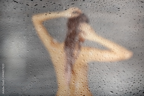 Canvas Print Young woman washing hair in shower