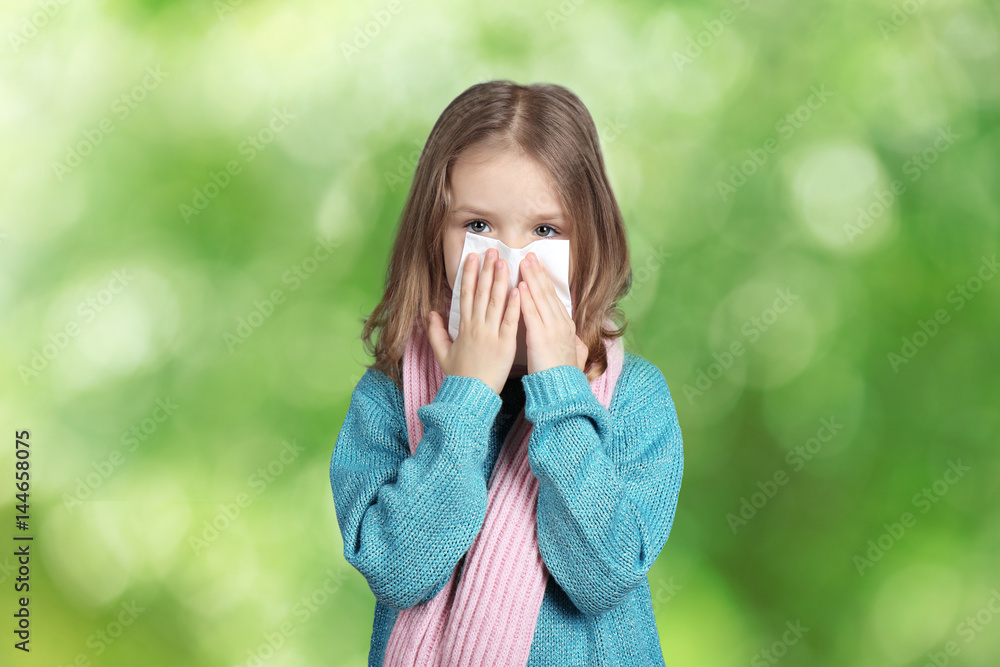 Seasonal allergy. Little girl with tissue on blurred background Seasonal allergy. Little girl with tissue on blurred background