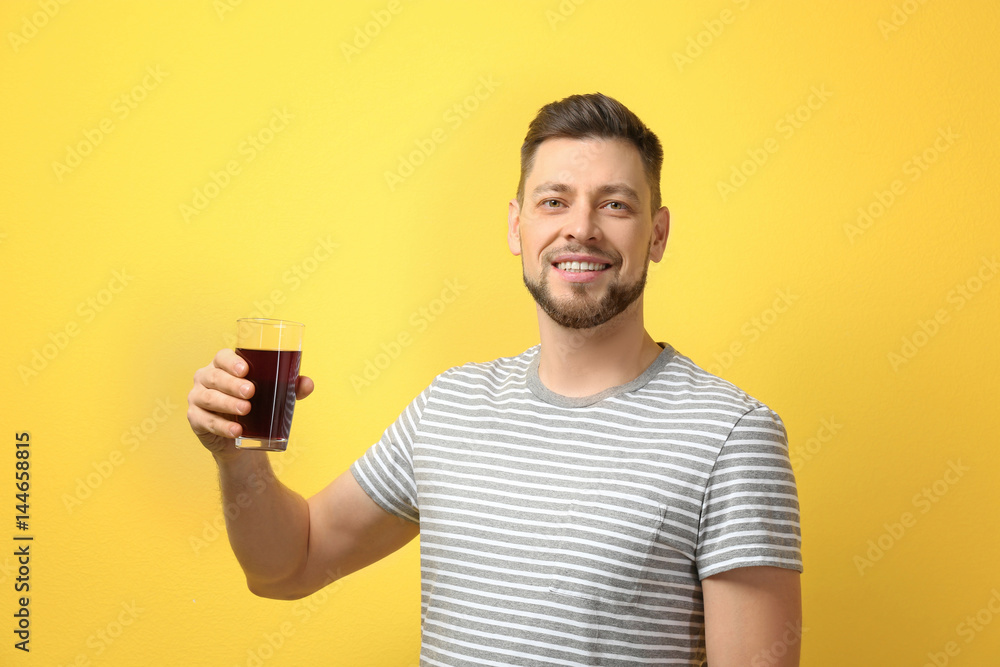 Handsome man posing with juice on color background Handsome man posing with juice on color background
