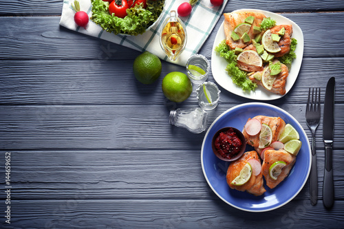 Delicious tequila lime chicken with ingredients on wooden background photo