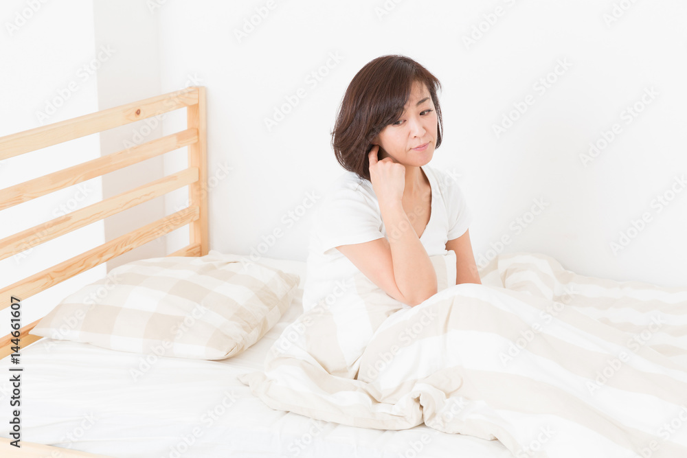 疲れたミドル女性　ベッド