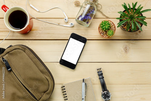 Top view accessories travel with mobilephone,sunglasses,bag,watch,notepaper,earphones,pen,cactus,coffee on table wooden with copy space.Travel concept.