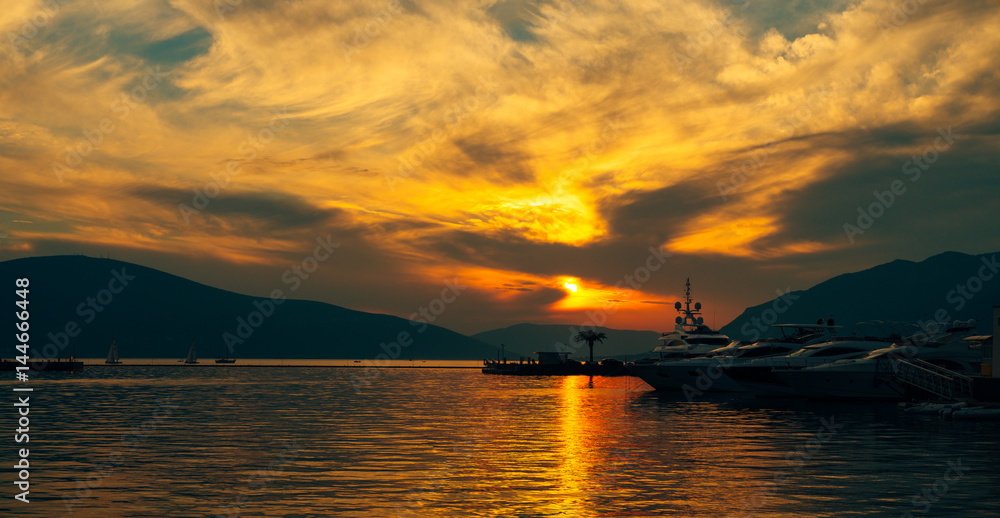 Yacht in the sea at sunset. Silhouette of a yacht on the background of the setting sun on the horizon