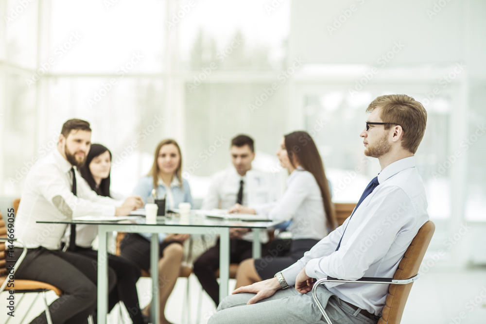 Fototapeta premium Manager sitting in an office chair in the background of business team working at Desk