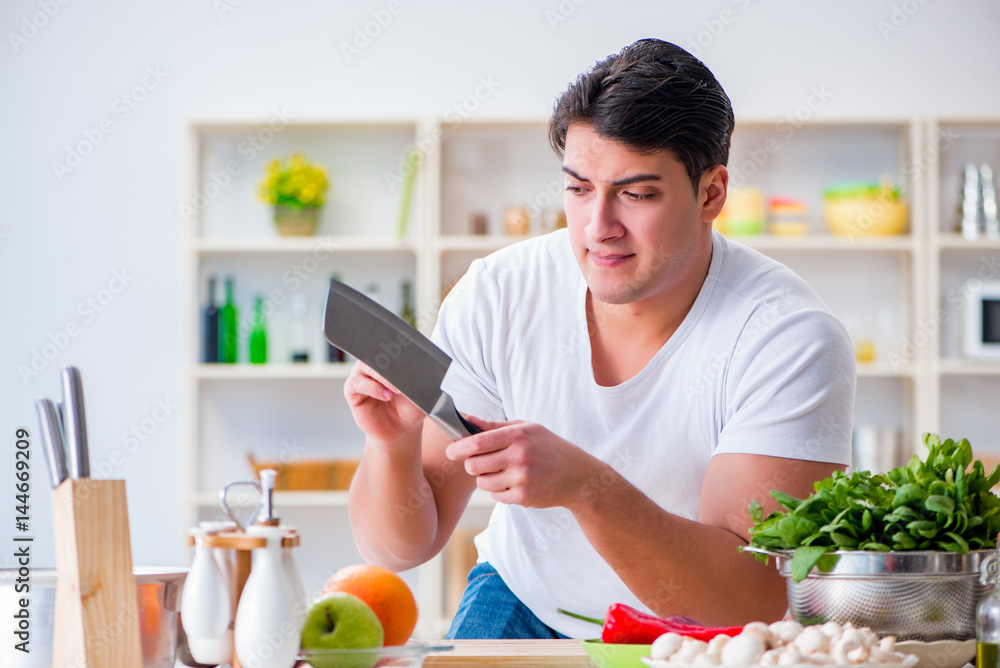 Young male cook working in the kitchen Young male cook working in the kitchen