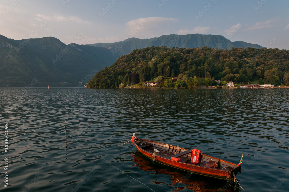 Lake Como and fisherman boat - early morning in summer season.