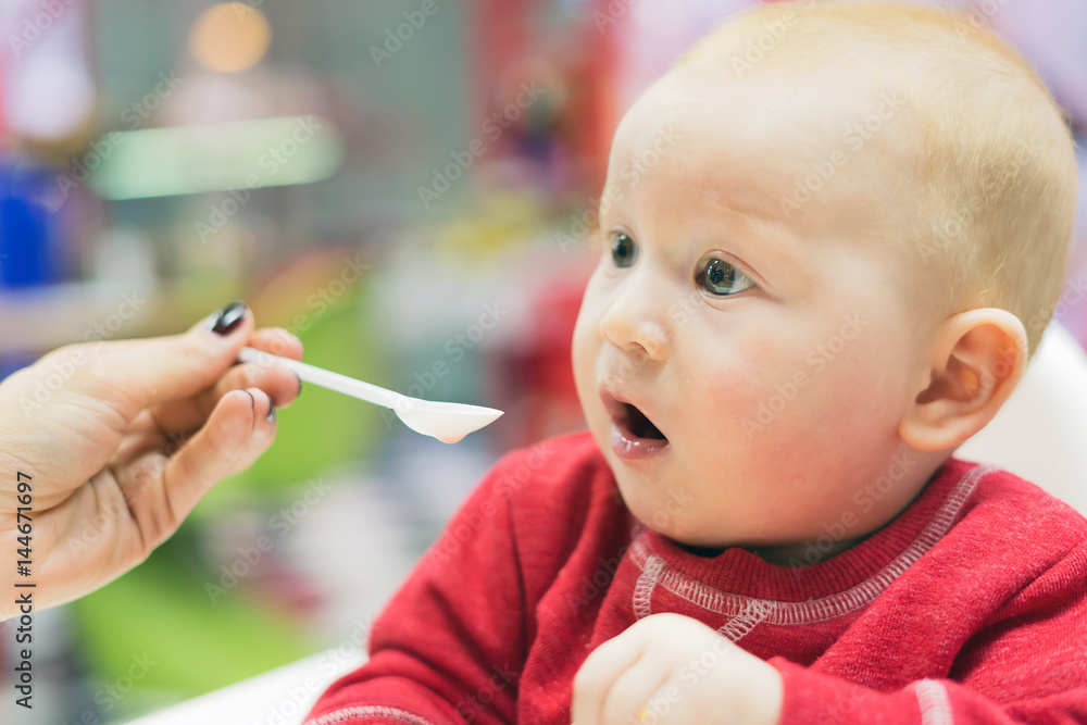 Mother feeding a little boy with a spoon Mother feeding a little boy with a spoon