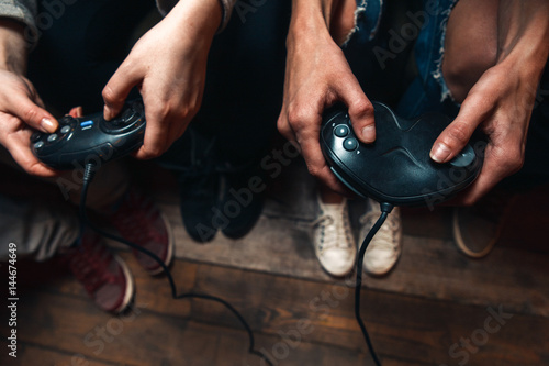 Video game competition of unrecognizable group of people with joysticks, close up view of hands. Fun leisure, high concentration, great tension, exciting tourney concept