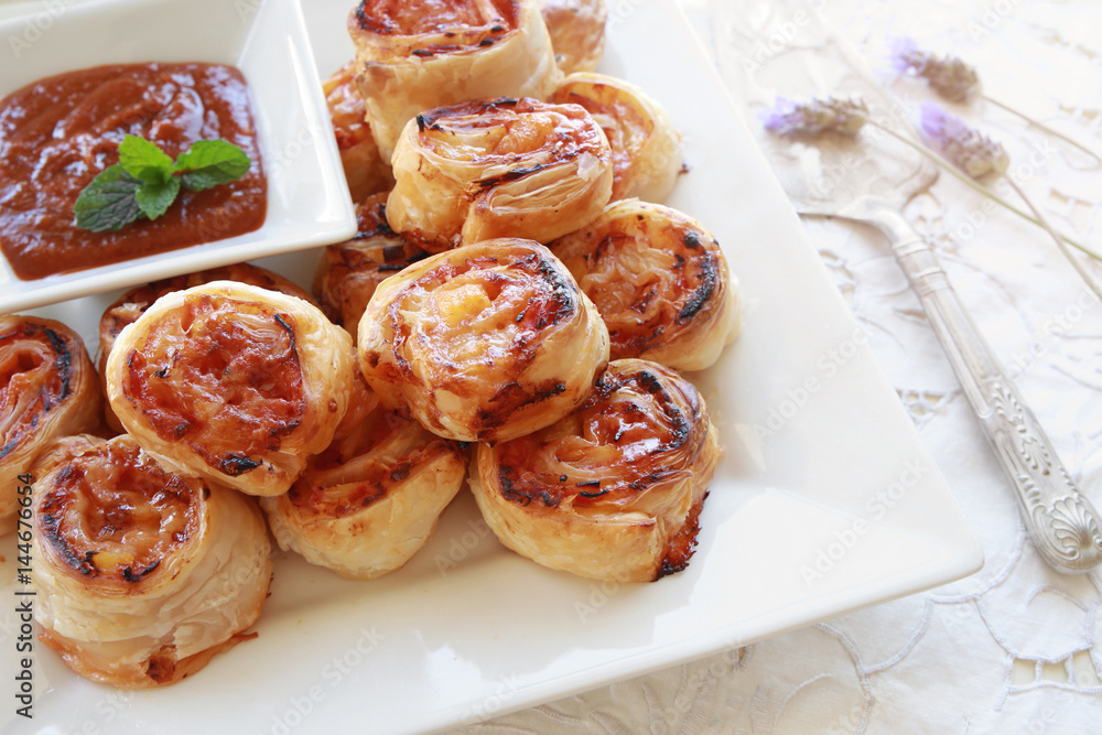 Hawaiian pizza rolls on white serving plate Hawaiian pizza rolls on white serving plate