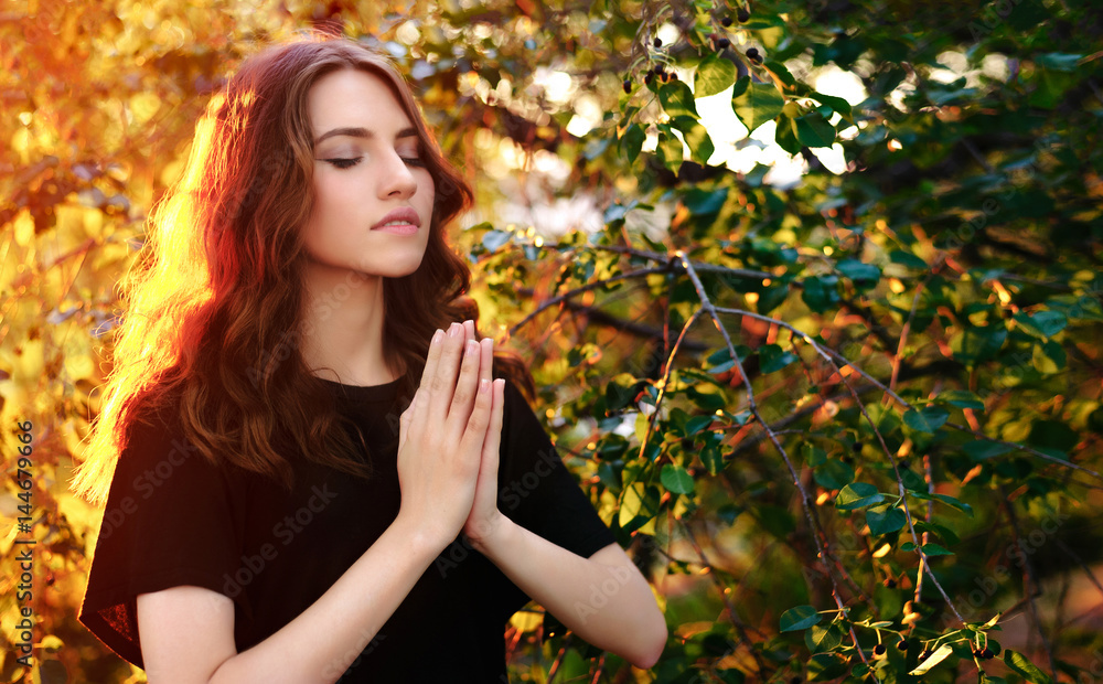 The girl prays in nature. eyes closed. The girl prays in nature. eyes closed.