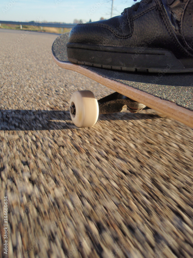 Skateboard Rolling Down Road