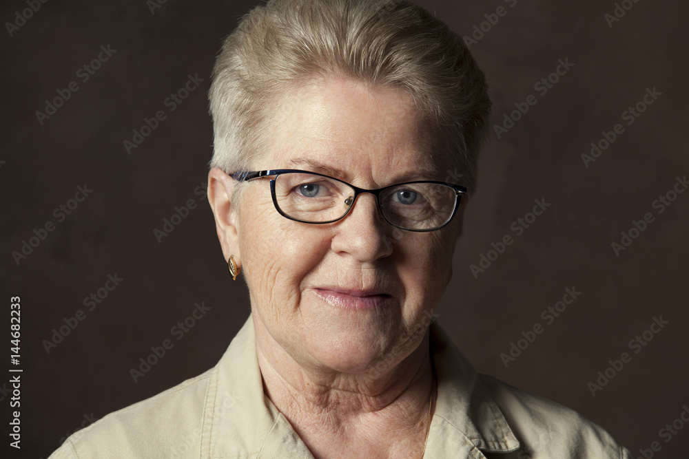 elderly woman in glasses on dark background
