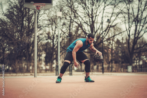 African-american streetball player practicing outdoors