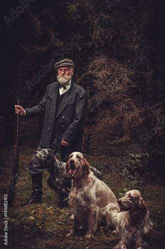 Senior man with dogs in a traditional shooting clothing.