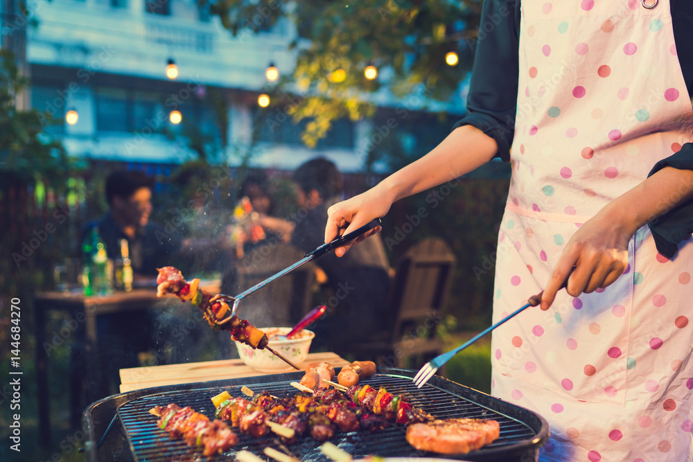 © torwaiphoto - Asian woman are cooking for a group of friends to eat barbecue