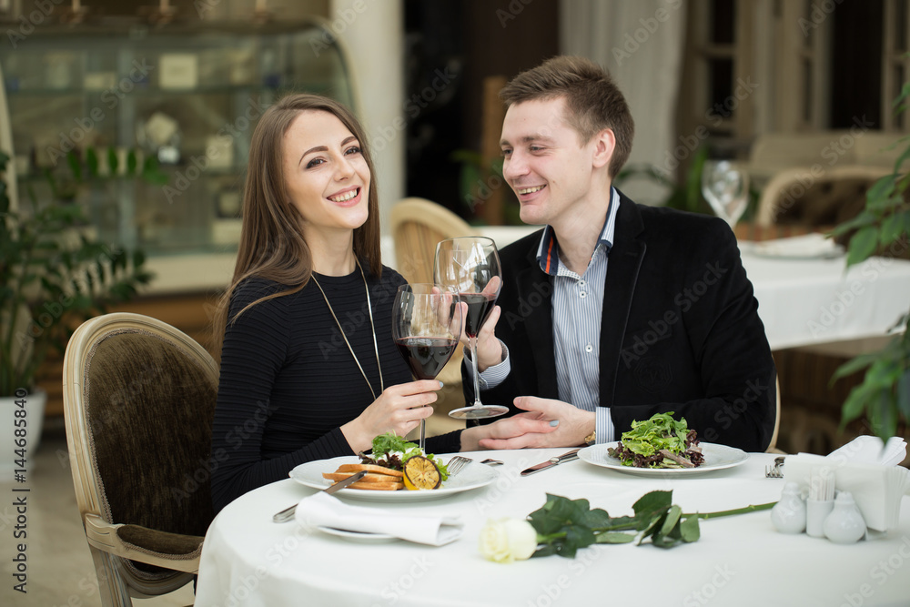 Happy couple in restaurant, enjoying the wine and salad Happy couple in restaurant, enjoying the wine and salad