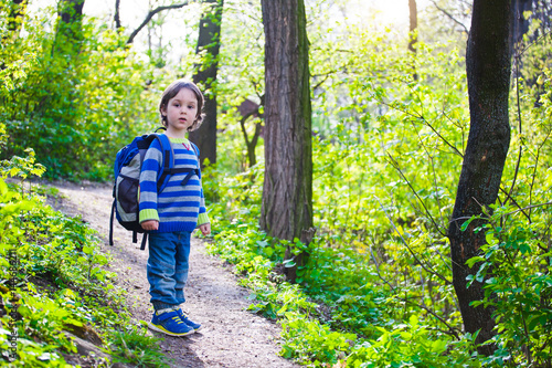 A child walks through the woods.