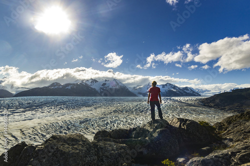 man standing on the stone above Grey glacier in patagonia at sunset