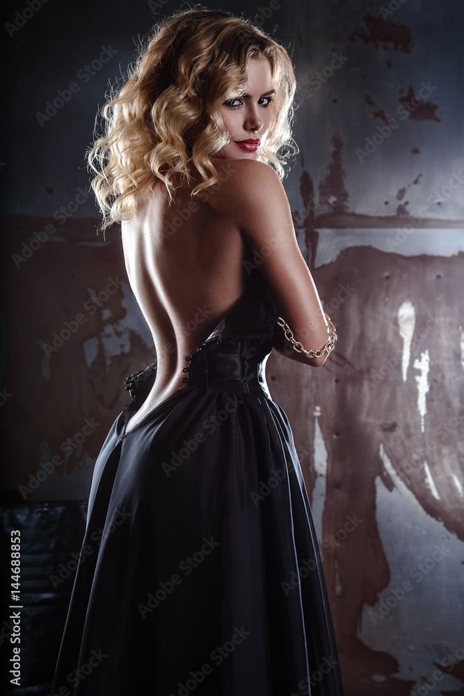 portrait of young sexy blonde woman in a black dress