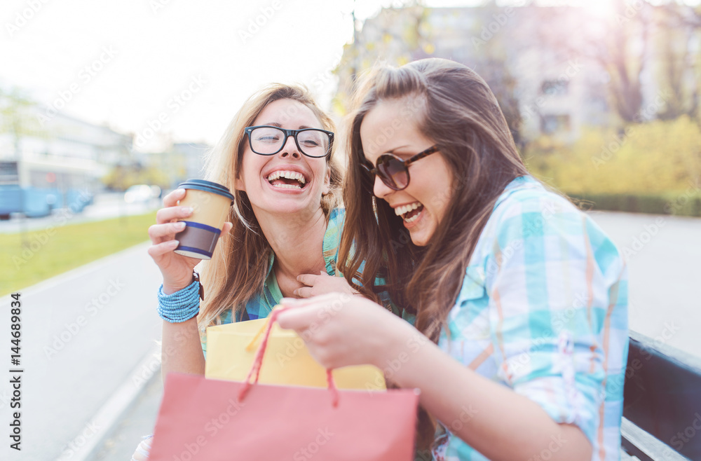 Shopping time. Beautiful women take a break after shopping. Consumerism, shopping, lifestyle concept Shopping time. Beautiful women take a break after shopping. Consumerism, shopping, lifestyle concept