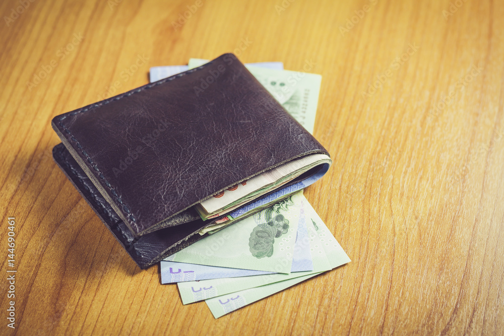 Black wallet with money on wooden table. Black wallet with money on wooden table.
