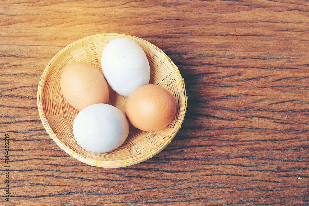 Eggs in basket with old beautiful wooden background.